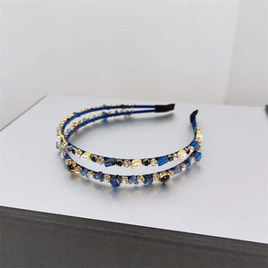 Detailed view of double-layer blue crystal headbands with pearls on gold metal frame