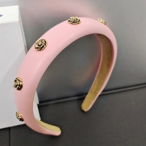 Detail of pink padded headband with golden camellia metal buckles and nonslip lining