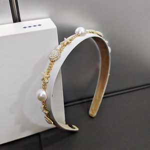 Detailed macro view of white satin headband with gold chain, pearls and starfish charms