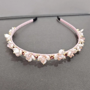 Detail of pink satin headband with white faux pearls and champagne crystal flower clusters