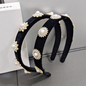 Close-up of black velvet headband featuring elegant pearl and rhinestone flower charms