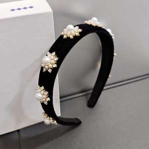 Close-up of velvet headband with golden flower clusters, pearls and sparkling rhinestones
