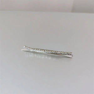 Detailed close-up of a silver Bobby pin with rows of sparkling white rhinestones