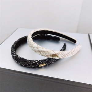 Detail of tweed fabric headbands featuring gold metal accents and woven texture finish