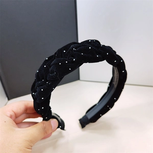 Detalle de diadema trenzada de terciopelo negro con puntos brillantes y dientes antideslizantes