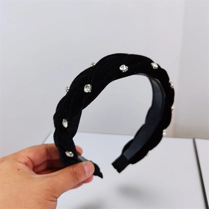 Detailed view of black velvet braided headband featuring sparkling crystal rhinestones