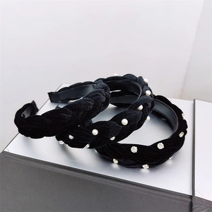Detailed view of black velvet braided headbands with pearl and rhinestone embellishments