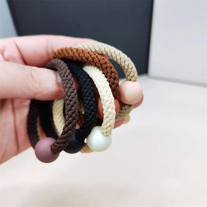 Gros plan d'élastiques à cheveux aux tons terre avec perles mates de style minimaliste