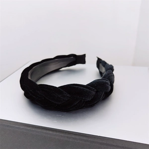 Detailed close-up of the woven black velvet headband with elegant braided texture