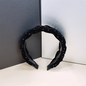 Detalle de diadema de terciopelo negro trenzado con perlas y peine antideslizante