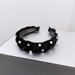 Detail of black velvet braided headband with white pearls for elegant hair styling