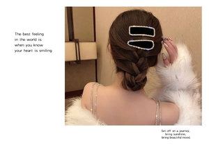 Détail de barrettes en velours noir serties de strass brillants et de perles blanches