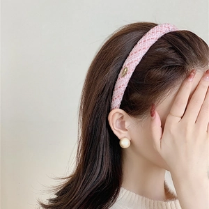 Detail of pink tweed headband with golden metal accent on a stylish female model