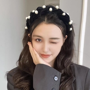 Close-up of black velvet braided headband with large white pearls for a high top hairstyle