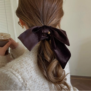 Deep brown velvet bow scrunchie with gold metal pendant for an elegant hair styling look