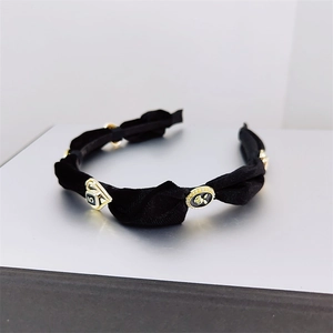Detailed close-up of velvet headband with vintage golden charms and number 5 ornament