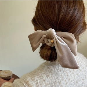 Velvet oversized bow hair scrunchie in champagne khaki with a gold charm detail
