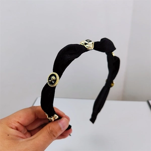 Detail of black velvet headband featuring vintage gold rose and heart metal ornaments