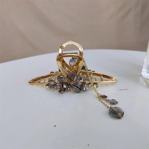 Pince à cheveux dorée élégante avec perles grises et pendentif à pompon décoratif