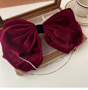 Detail of burgundy velvet bow hair clip with sparkling rhinestone fringe tassels in a gift box