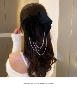 Detail of elegant black velvet hair bow with sparkling rhinestone tassel fringe dangles