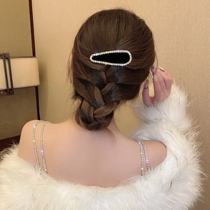 Barrette à cheveux élégante en strass noirs sur cheveux ondulés pour une coiffure raffinée