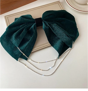 Detail of dark green velvet bow hair clip featuring sparkling silver rhinestone tassels