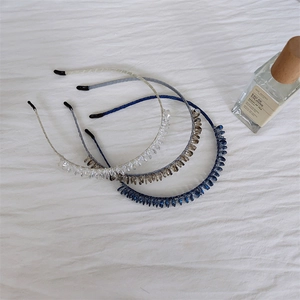 Detail shot of elegant crystal leaf headbands in clear white, amber, and navy blue