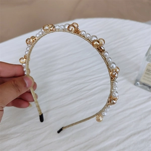 Détail du serre-tête fait main avec perles blanches et cristaux ambrés sur fil doré