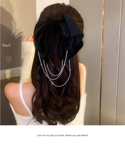 Detailed back view of a velvet bow hair clip with sparkling silver rhinestone tassels