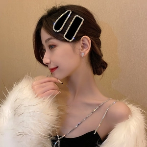 Élégant ensemble de barrettes noires avec chaînes dorées et strass sur un modèle