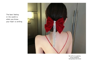 Detail of red velvet bow hair clip with sparkling silver rhinestone tassels for brides