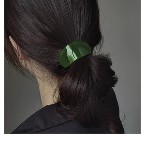 Close-up of deep green acetate hair tie for low ponytail with glossy finish