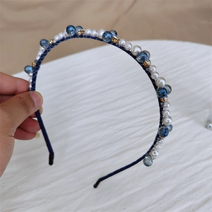 Détail de perles de cristal bleu et de perles blanches faites à la main sur un serre-tête