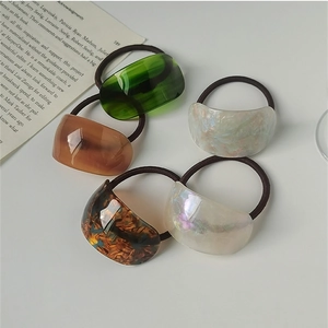 Detailed close-up of colorful acetate ponytail holders with elegant shell textures