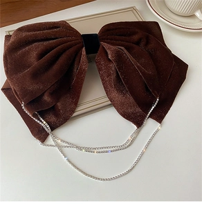 Detail of a dark brown velvet bow hair clip with elegant three-layer rhinestone tassels