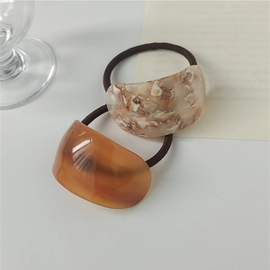 Macro detail of tortoiseshell and marble acetate hair ties with elastic bands set