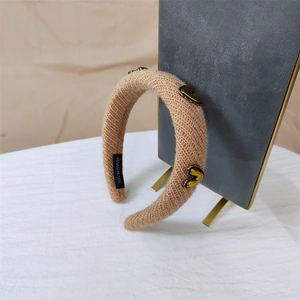 Thick beige knitted headband with gold heart metal charms and handmade craft details