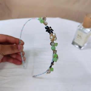 Detail van een gebloemde hoofdband met lichtblauwe stof en kristallen zirkoon-accenten