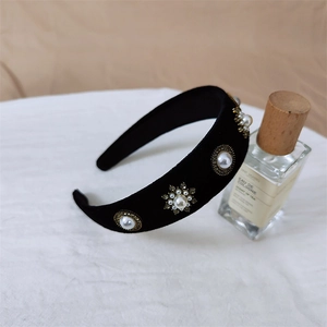 Détail d'un serre-tête en velours avec des perles et des cristaux sur métal doré