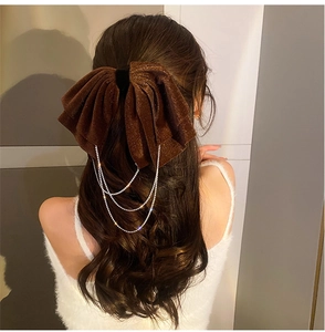Detail of velvet bow hair clip with sparkling silver rhinestone fringe tassels on model