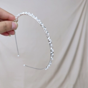 Silver metal headband with white pearls and celestial star moon charms on beige cloth
