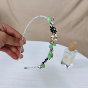 Bloemen haarband met groene kristallen en zwarte bloemen voor een elegante haarstijllook