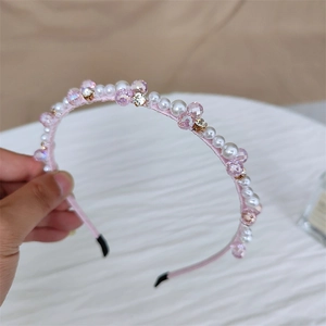 Détail de perles de cristal rose et de perles sur un serre-tête artisanal avec strass