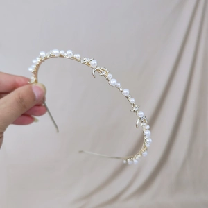 Serre-tête doré avec étoiles, lunes et perles sur un fond de tissu texturé