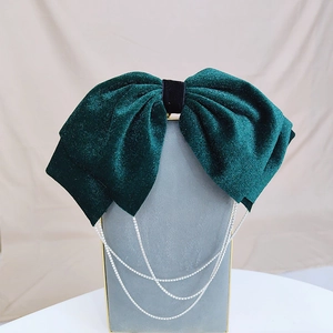 Detail of dark green velvet bow hair clip featuring elegant silver rhinestone tassel fringe