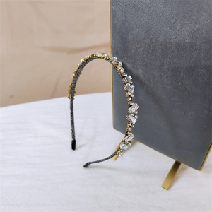 Détail d'un serre-tête baroque vintage orné de cristaux et perles sur fond gris