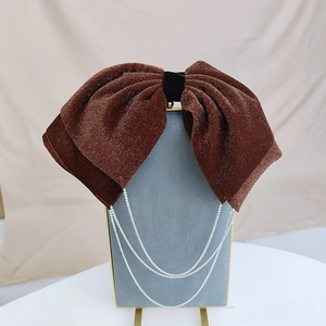 Detail of a brown velvet bow hair clip with sparkling silver diamond fringe tassels