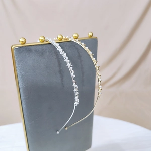 Detail of star and moon metal headbands with imitation pearls on a velvet display stand