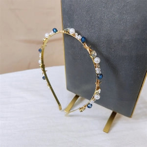 Detail of gold metal headband with pearls, blue crystals, and starfish charms